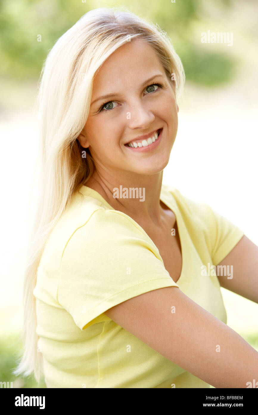 Portrait Of Young Woman Sitting In Park Stock Photo - Alamy
