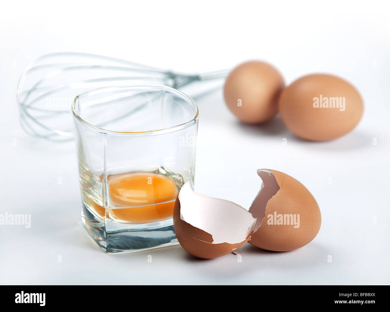 Egg shell and yelk in glass on blue toned background Stock Photo