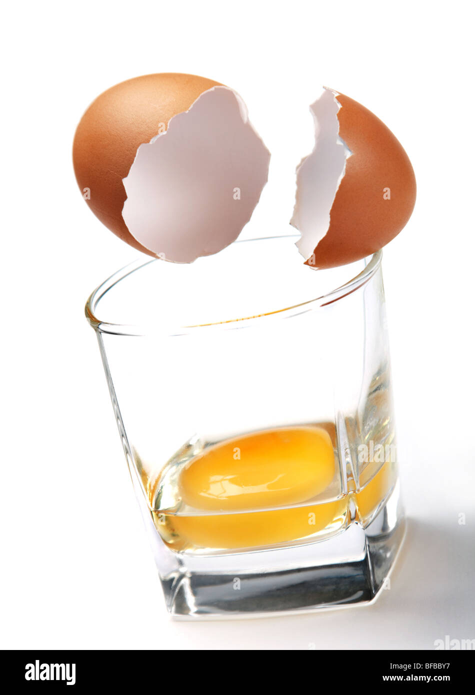 Brown egg shell and yelk in glass Stock Photo