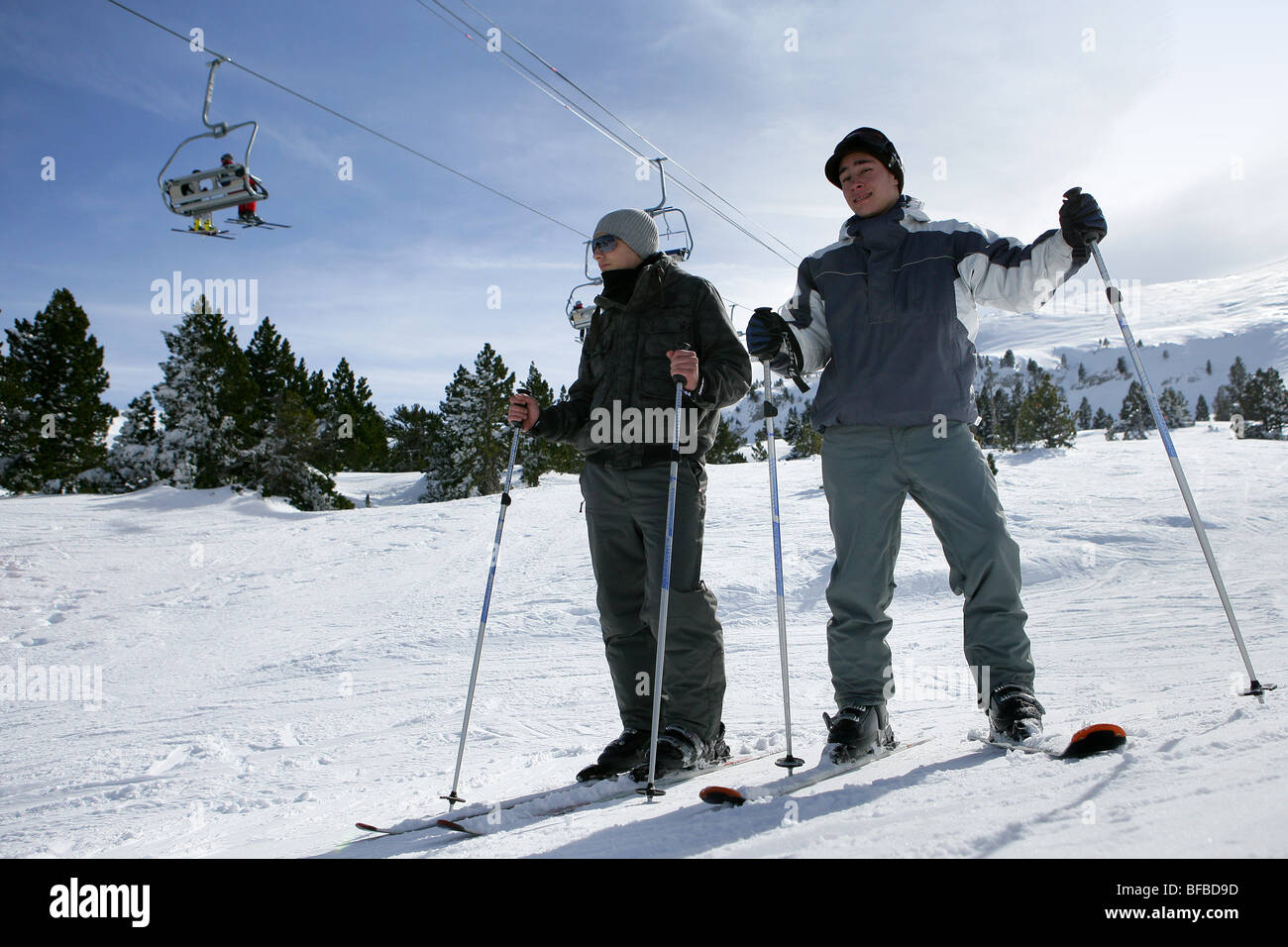 Skiers on a piste with a ski-lift in the background Stock Photo - Alamy