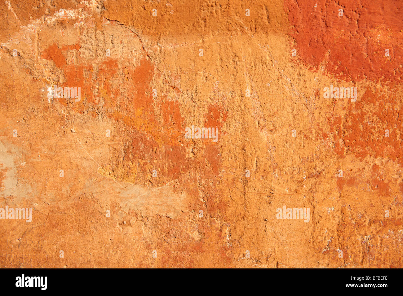 Orange yellow painted plater wall with ageing paint surface, rustic texture Stock Photo