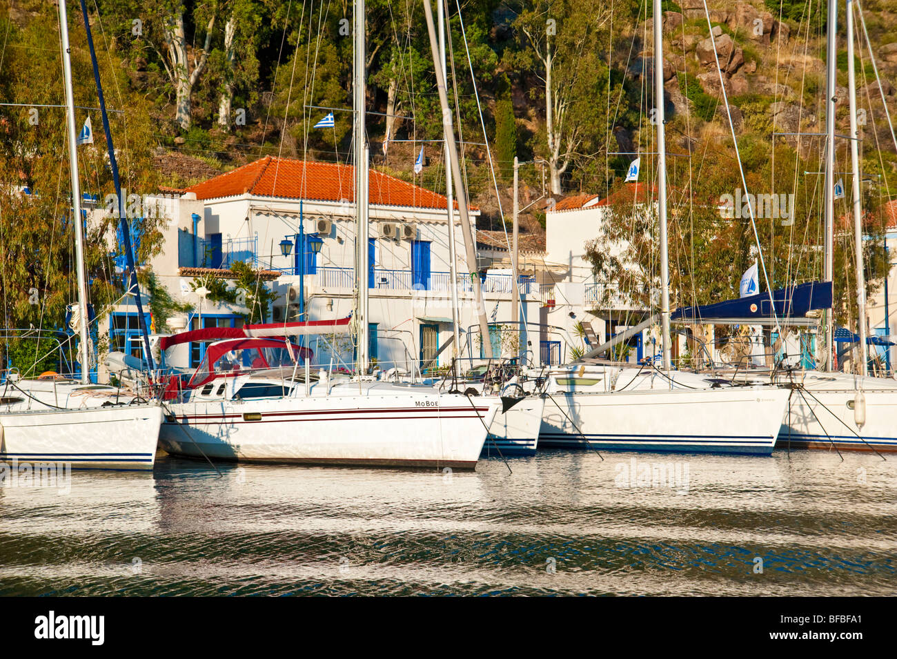 Sailing yachts mooring in front of houses at Poros island, Greece Stock