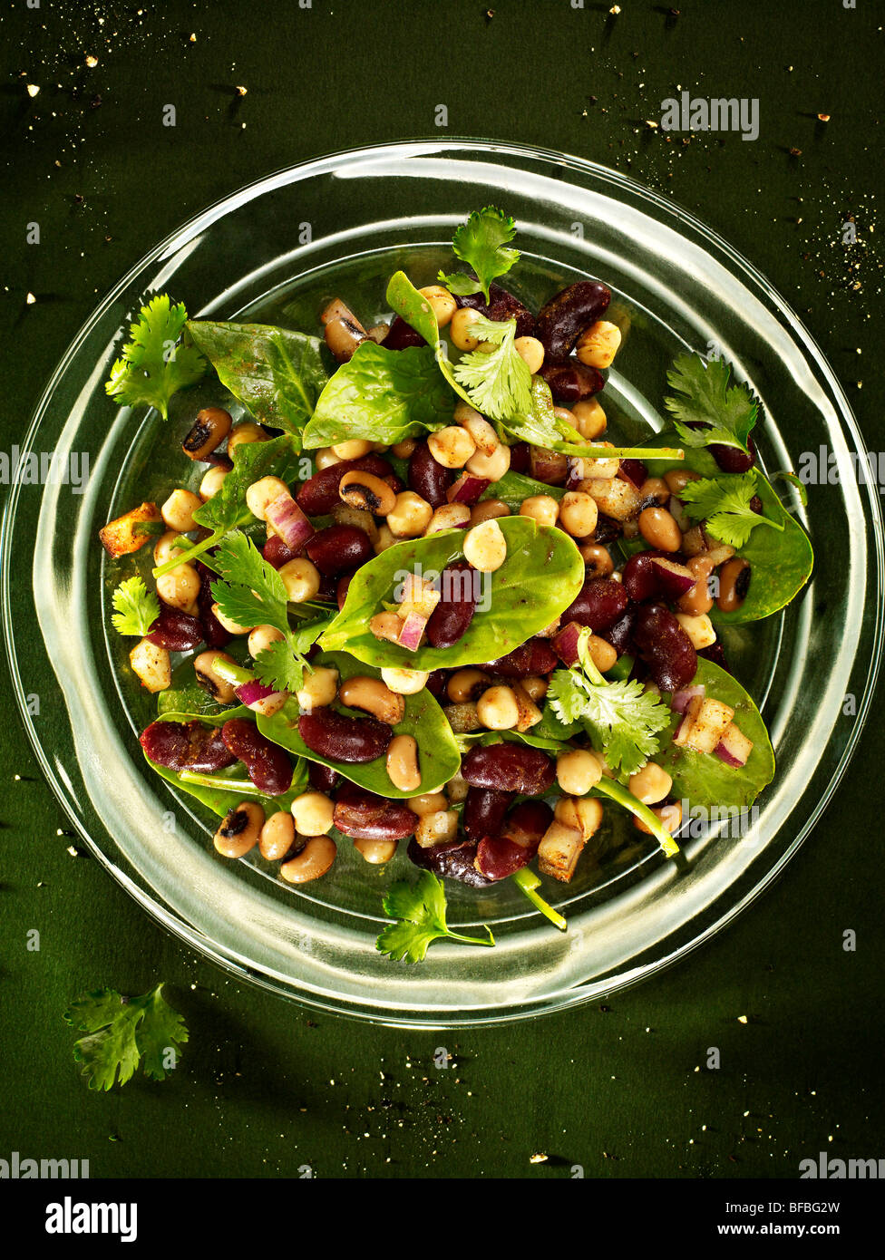 Bean salad, chickpeas, kidney beans, and black eyed beans with spinach, red onion and coriander. Stock Photo