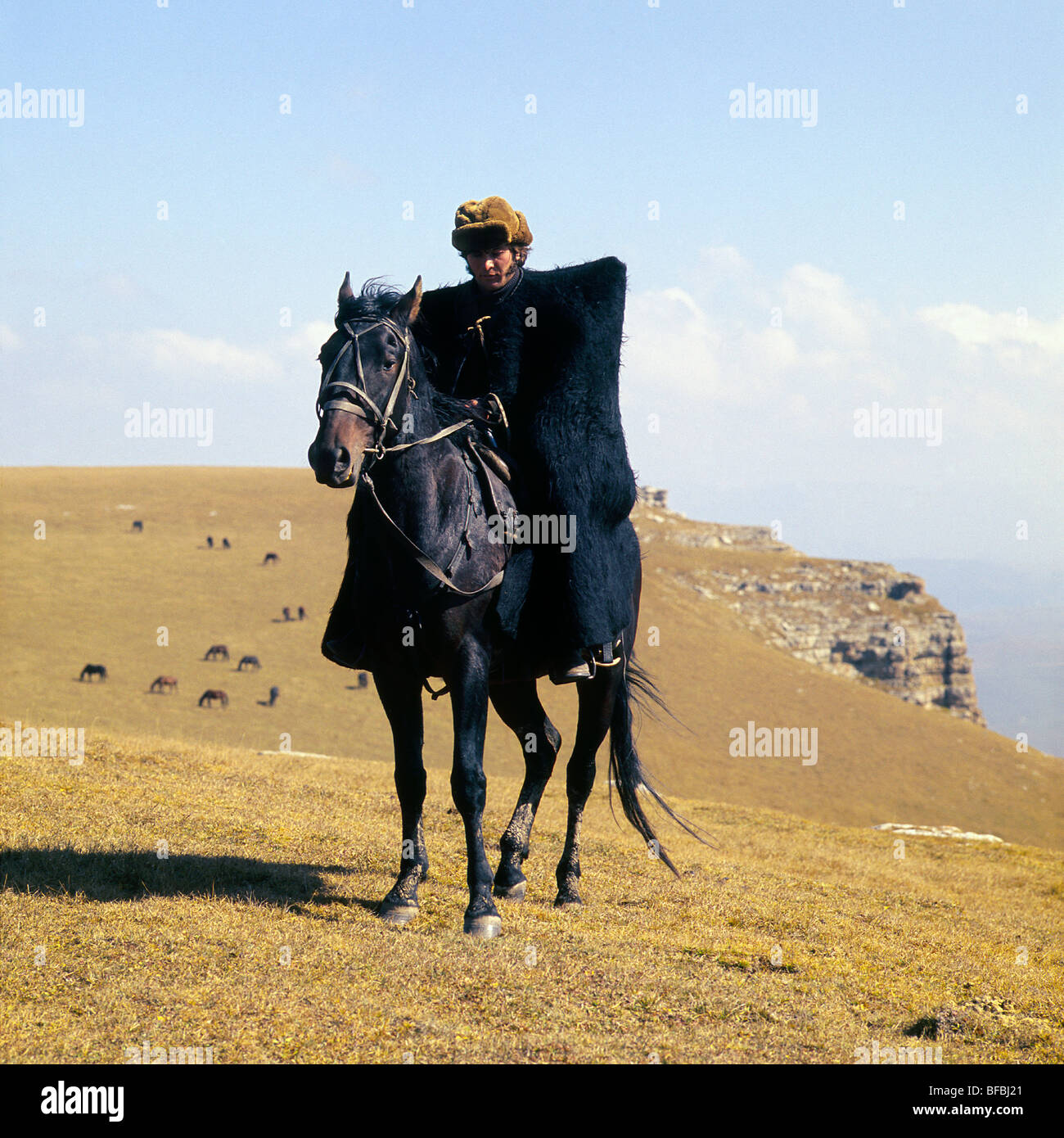 Kabardine horse ridden by cossack in Caucasus mountains, wearing traditional clothes Stock Photo