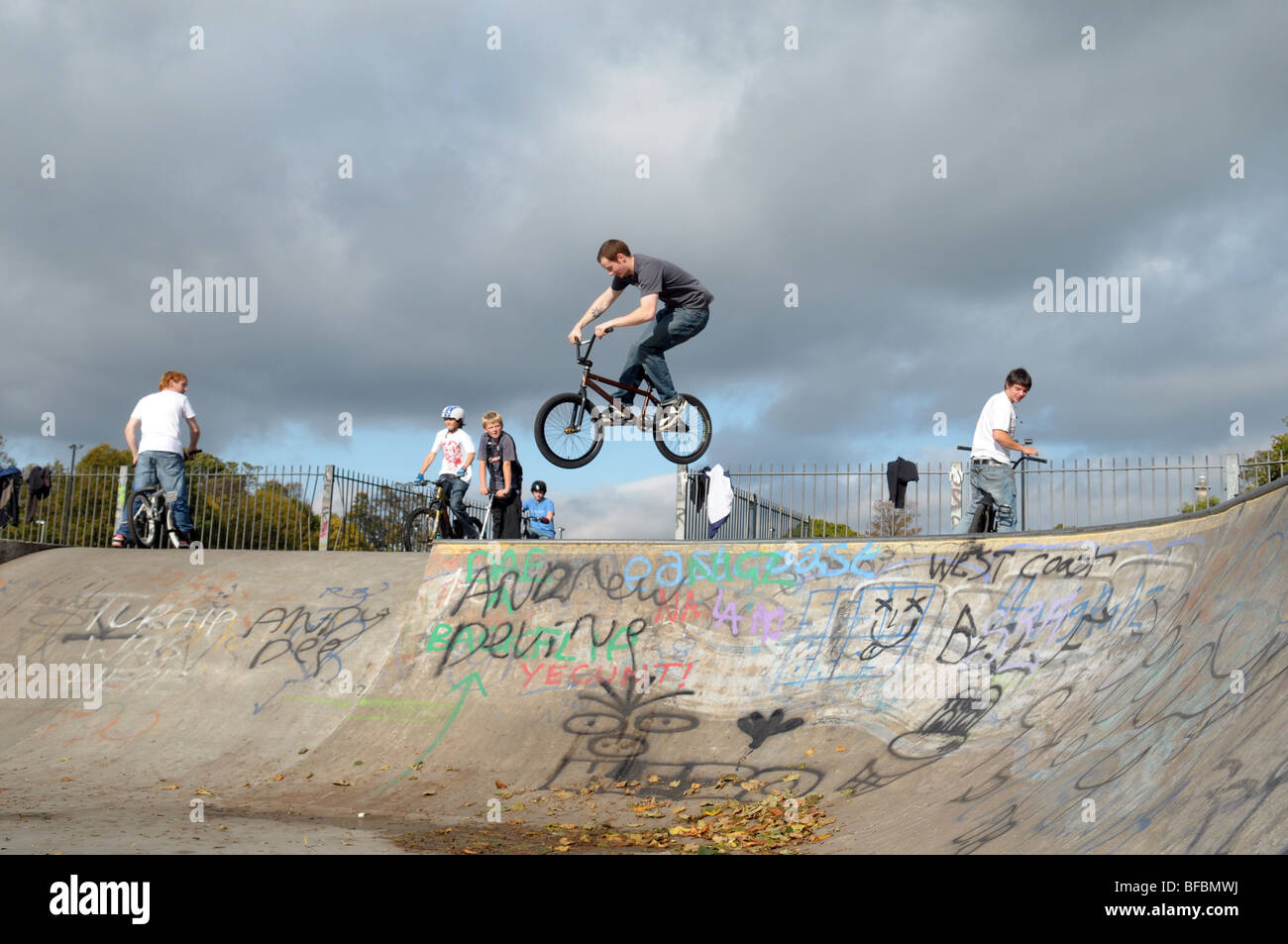 Kids and teenagers aged from around 10yrs to 16yrs playing in a skatepark. Stock Photo