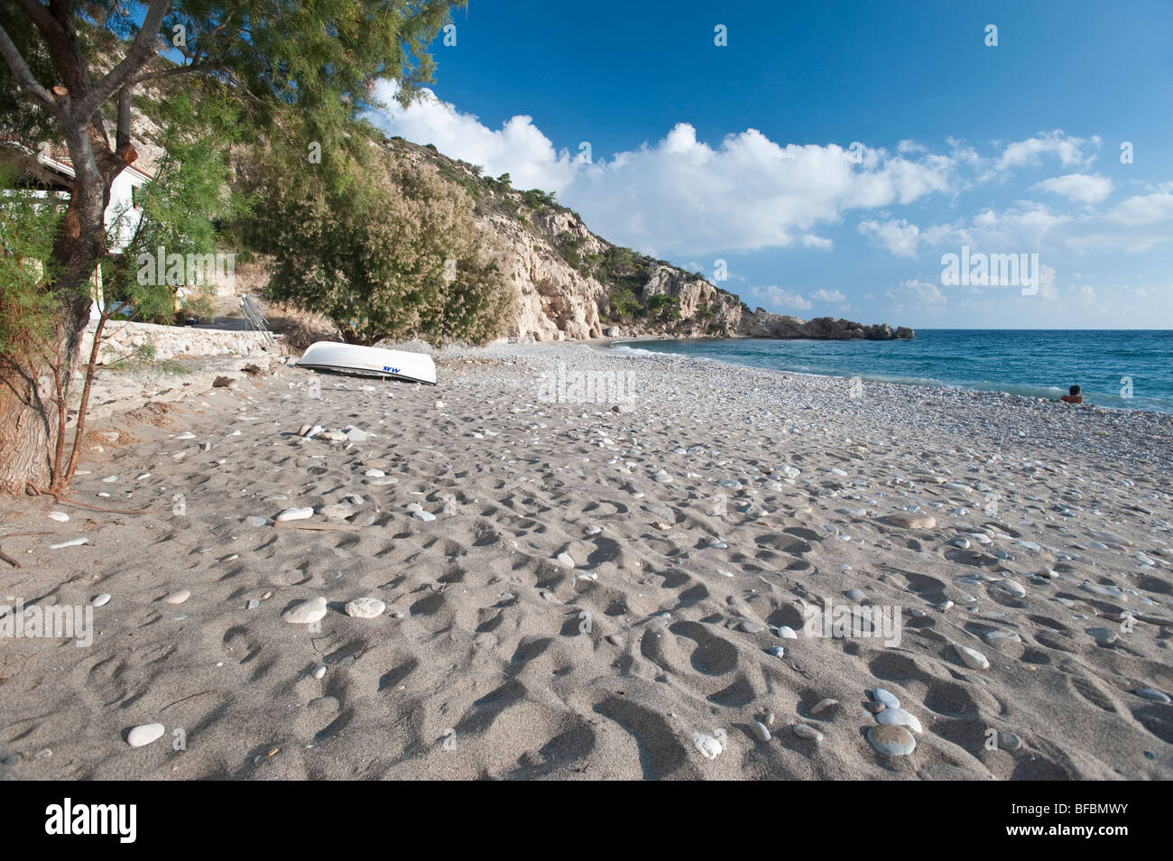white clouds in the blue aegean sky over a sandy beach on a greek island Stock Photo