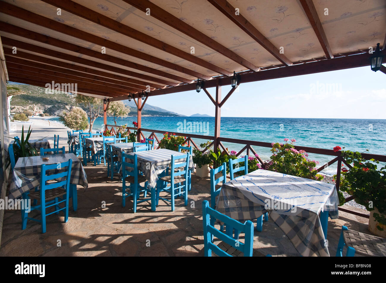 Blue chairs and tables in a greek tavern on the beach Stock Photo