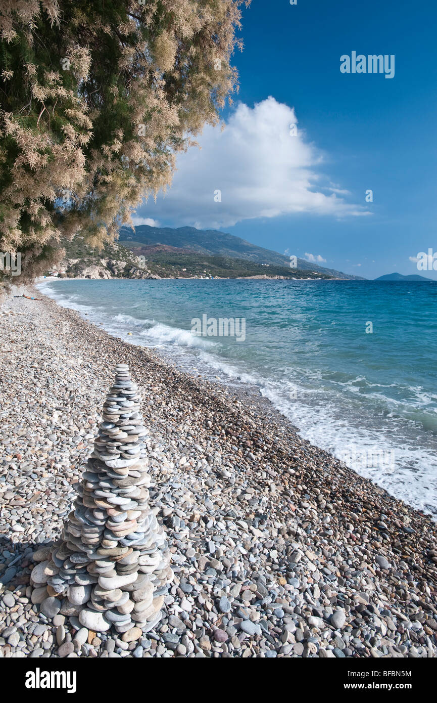 beach with pebbles and tamrisk trees in greece Stock Photo