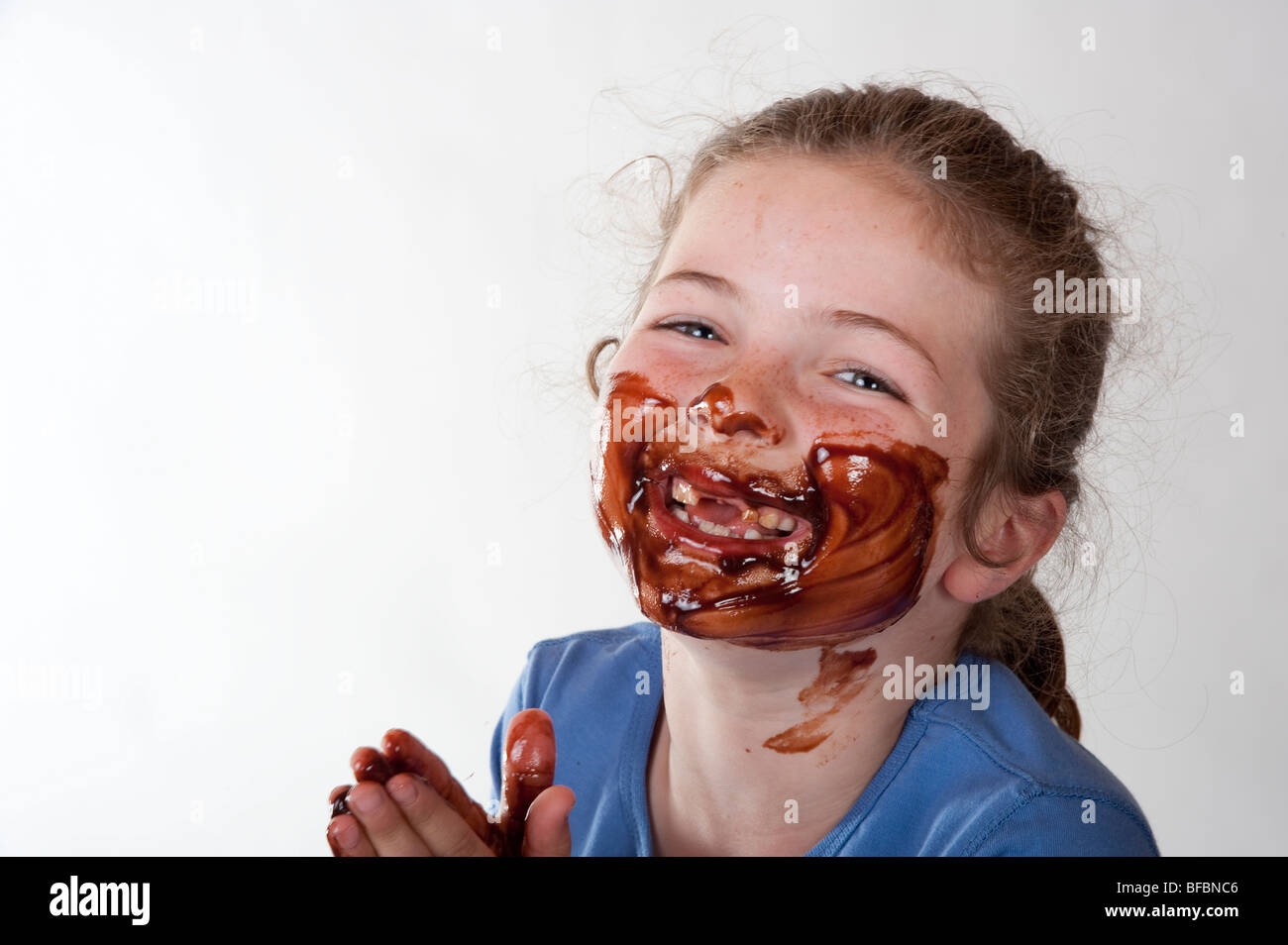 little girl laughing with chocolate covered face Stock Photo