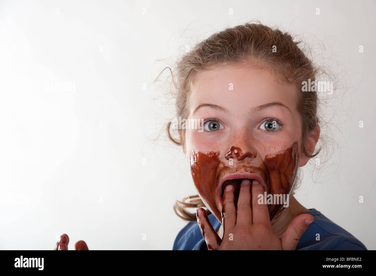 surprised little girl with chocolate covered face Stock Photo