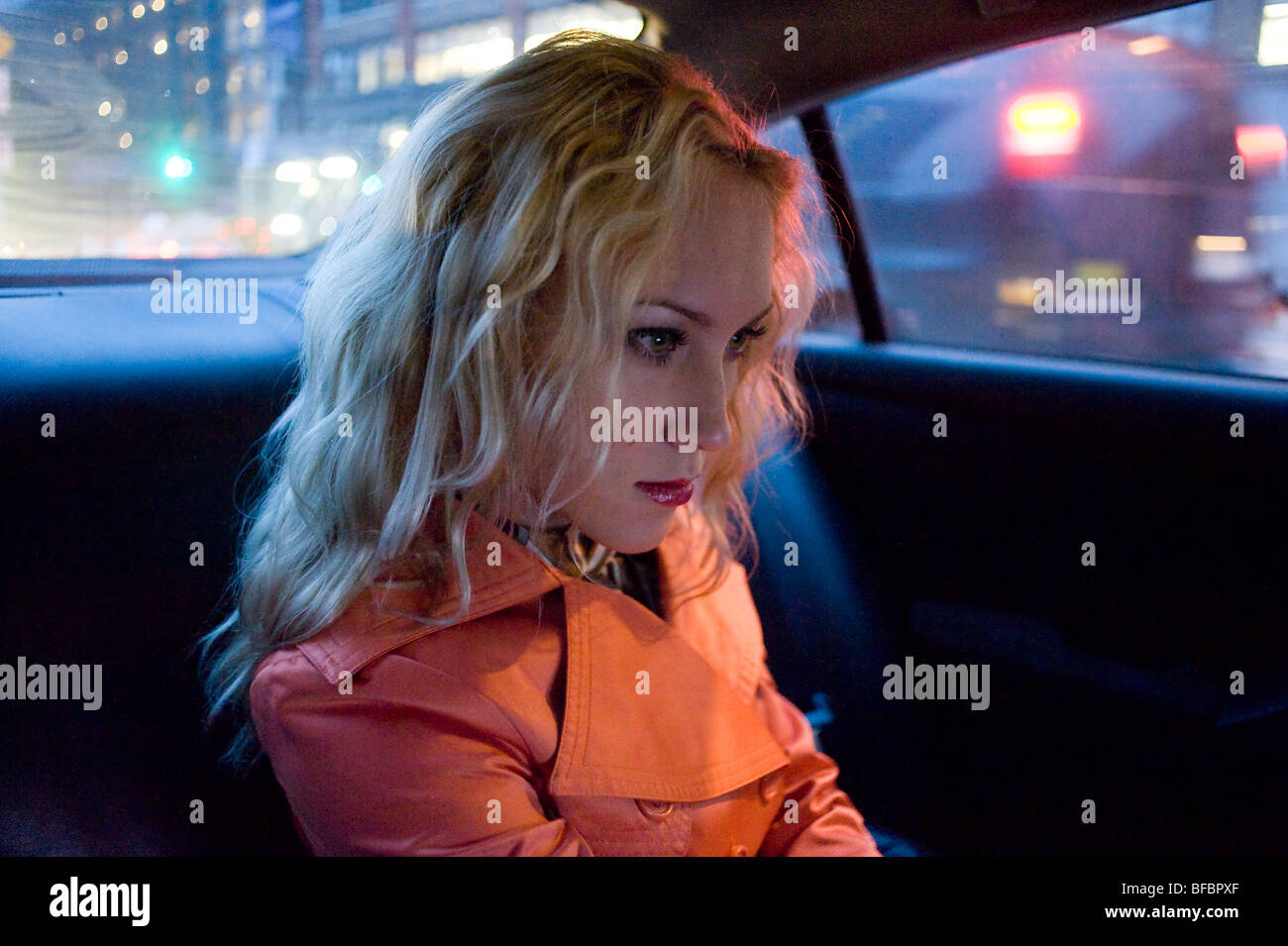 Determined woman riding in taxi cab at night New York City Stock Photo