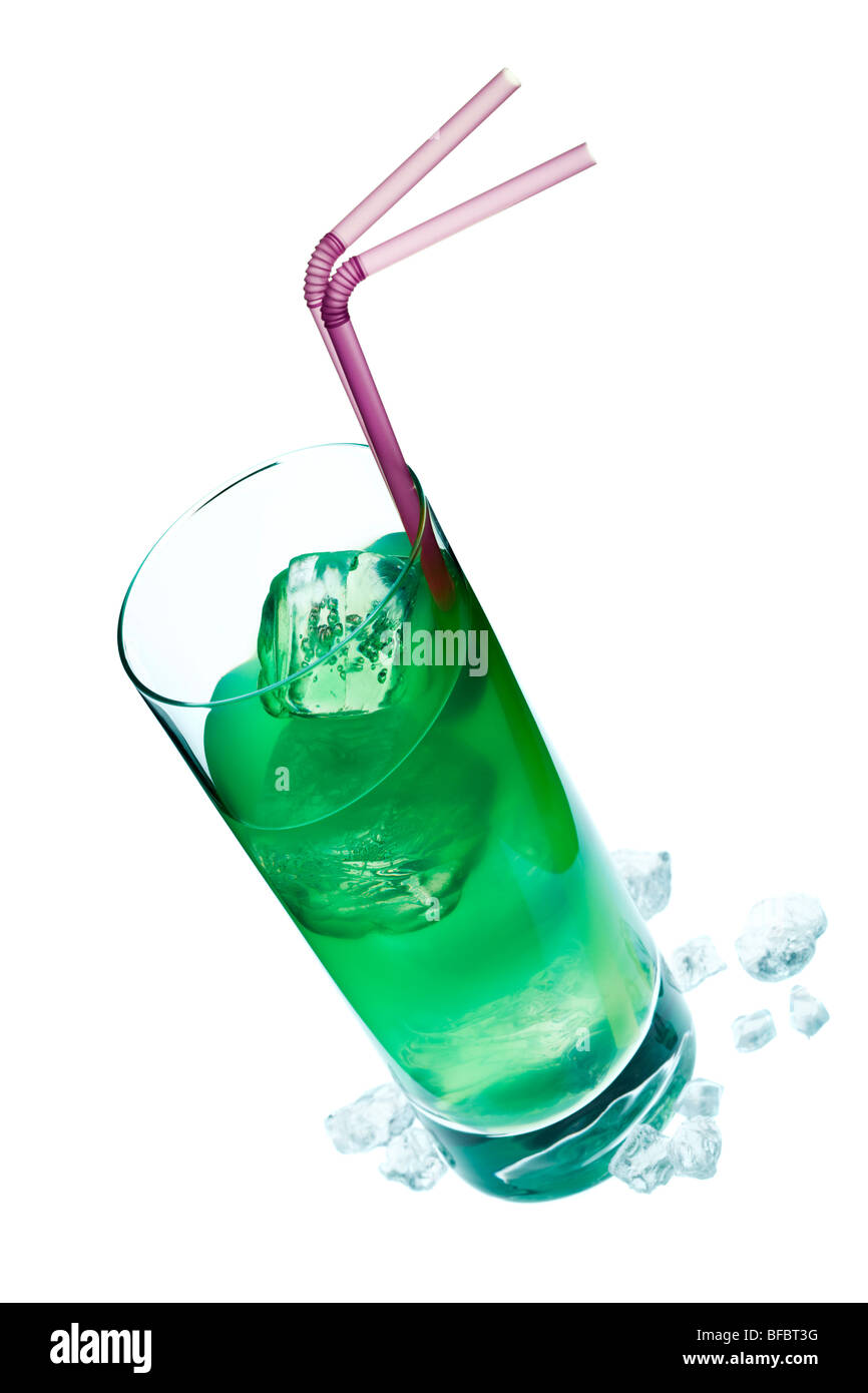 green coloured longdrink with ice cubes and purple drinking straws on white surface with crushed ice, tilted view Stock Photo