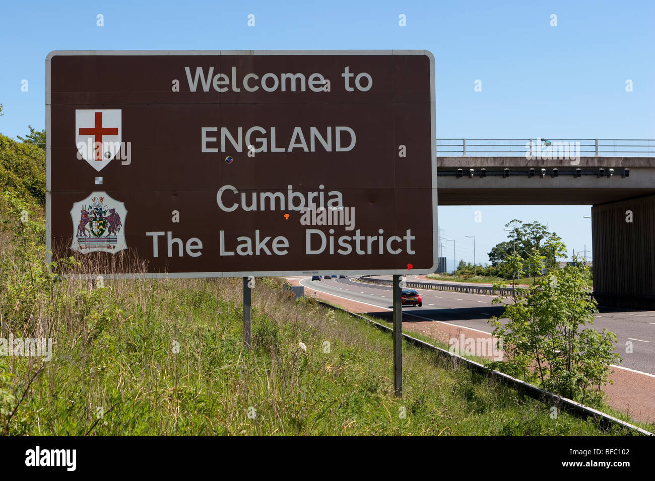 Motorway cars  Welcome to England border sign,  Cumbria The Lake District Stock Photo