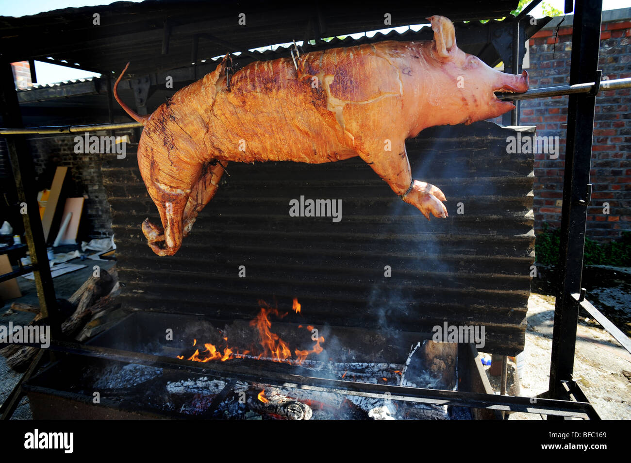Hog roast turns on a spit Stock Photo