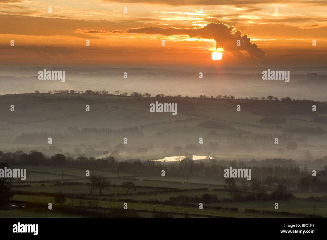 Sunrise, mist fills the valley of Wharfedale , Near to Harrogate in North Yorkshire, a power station sends out plumes of smoke Stock Photo