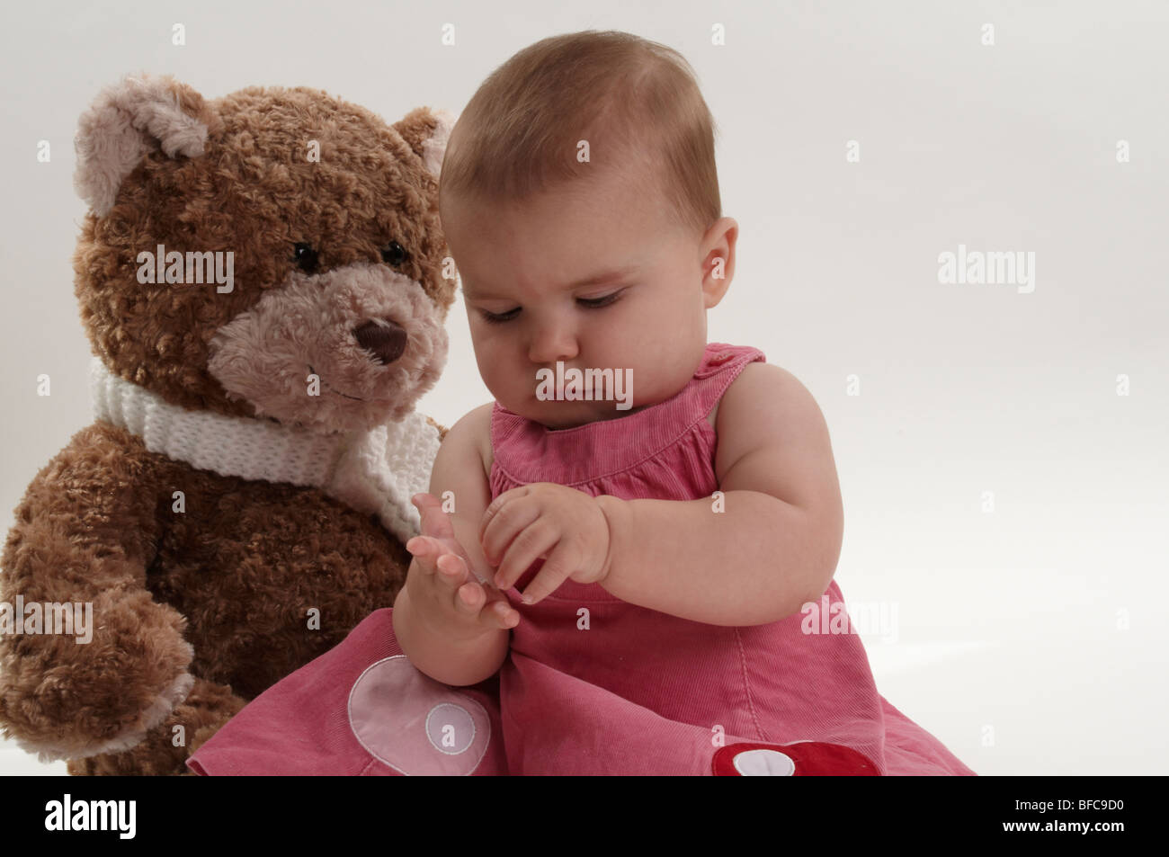 Baby Girl and her Big Brown Teddy Stock Photo