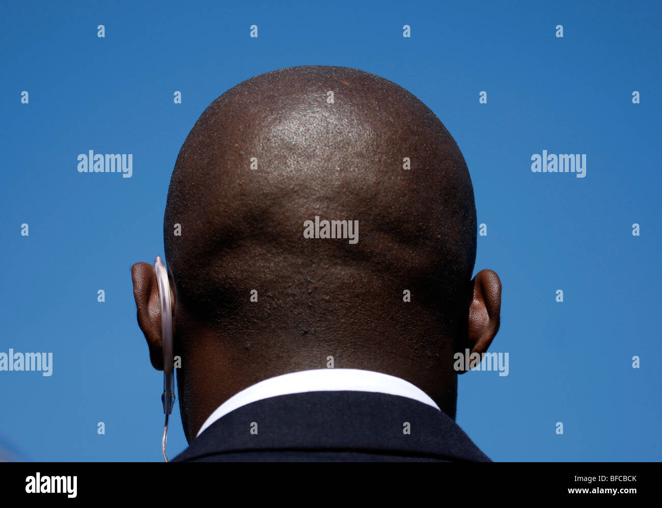 Bald head of black security guard against blue sky Stock Photo Alamy