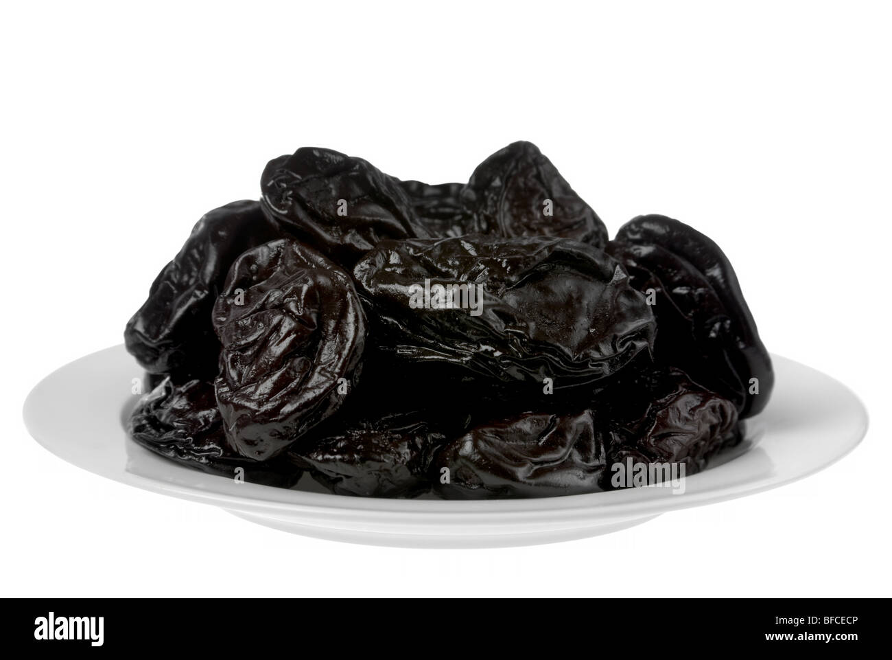 Dry prune fruit in white plate detail Stock Photo