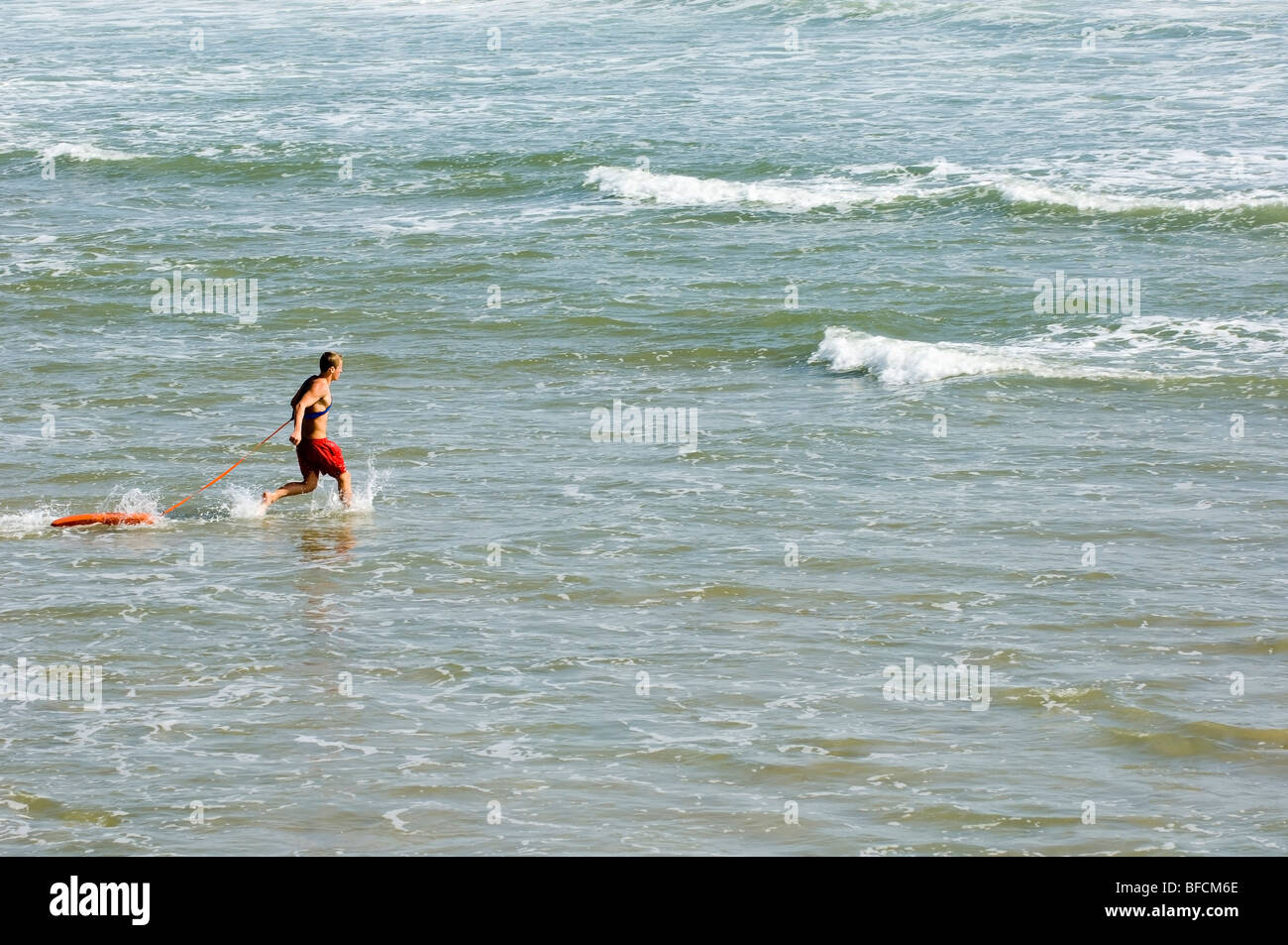 lifeguard running to rescue a drowning person Stock Photo Alamy