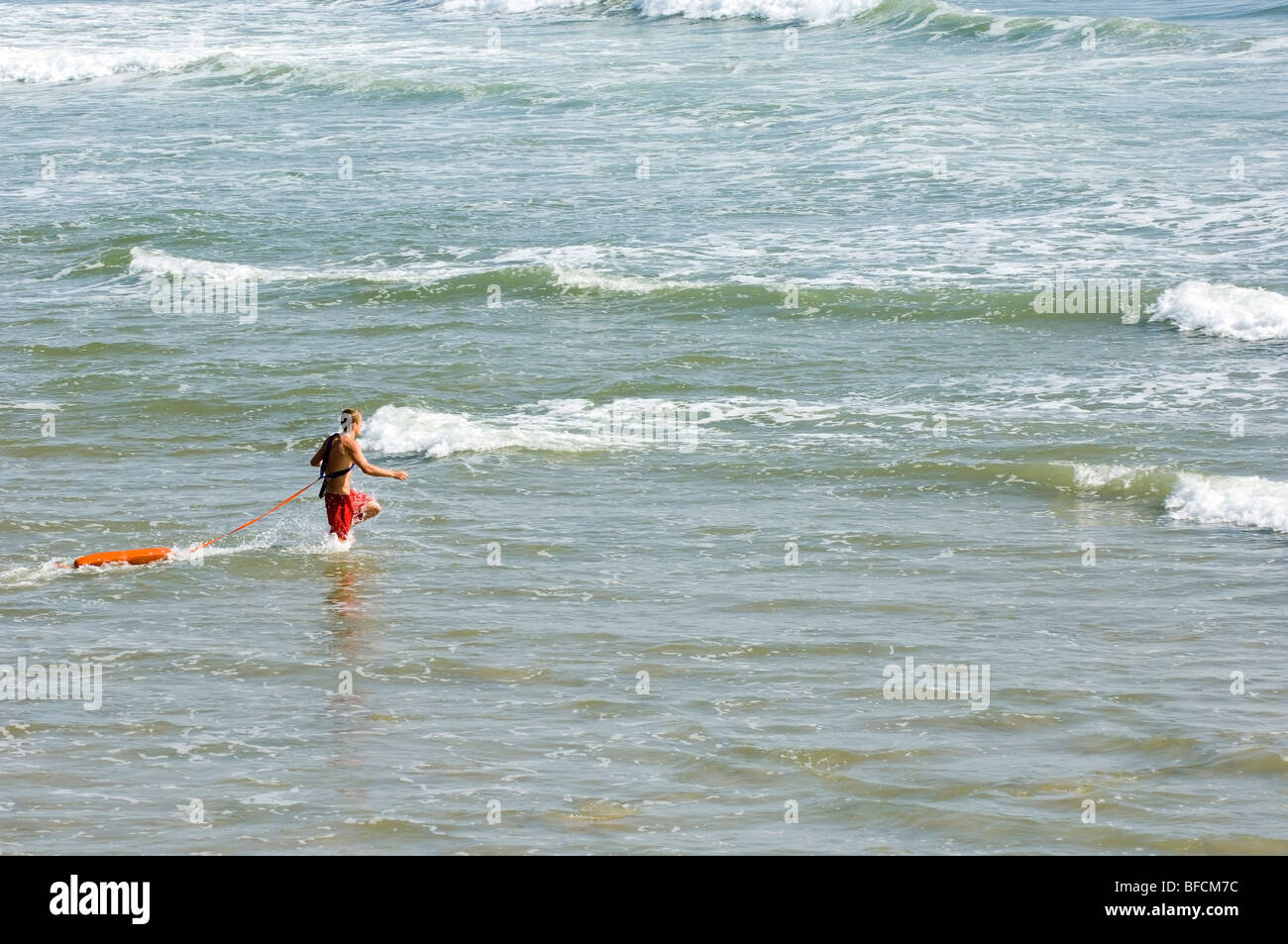 lifeguard running to rescue a drowning person Stock Photo Alamy