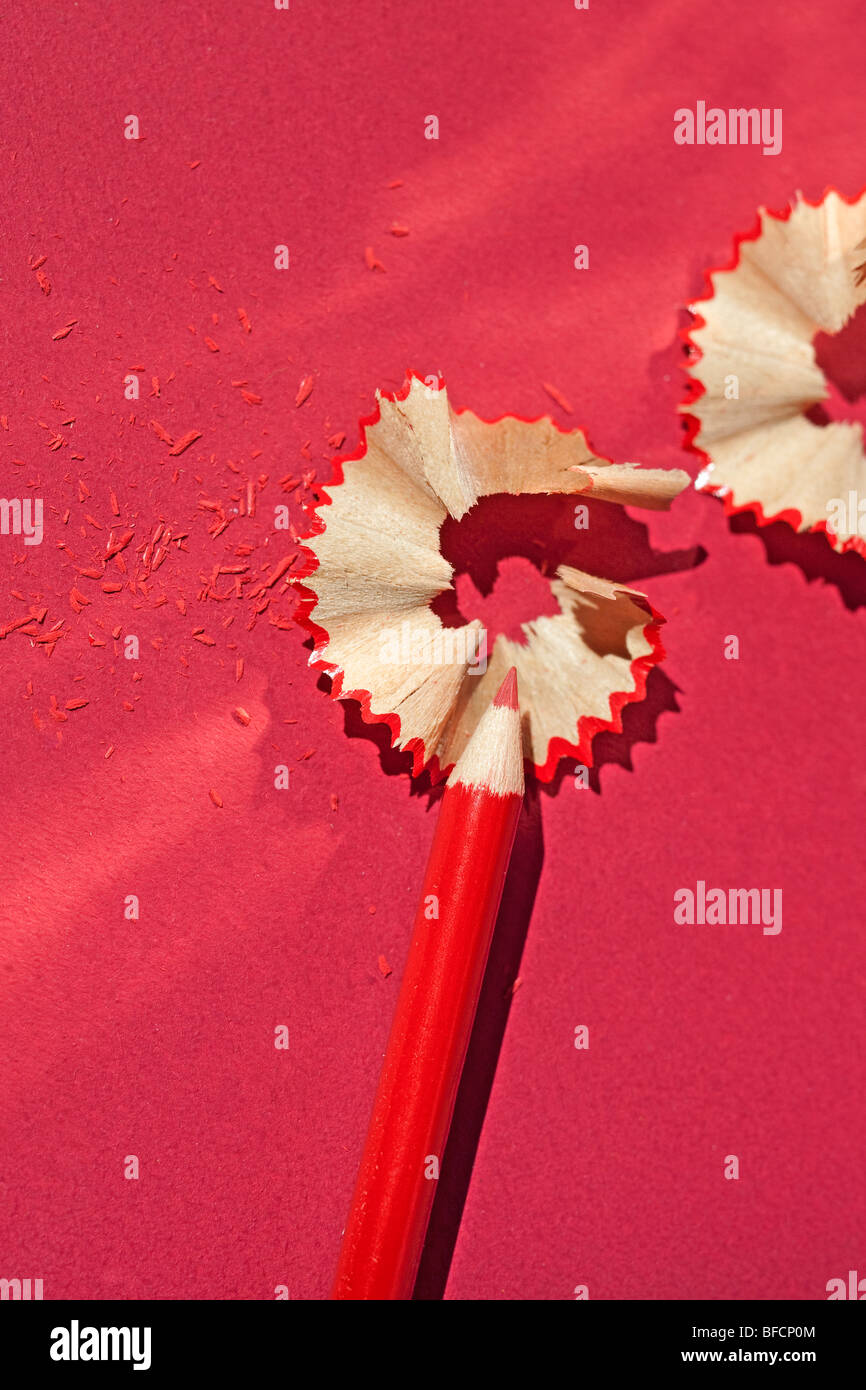 Red colored pencil still life with pencil shavings. Stock Photo
