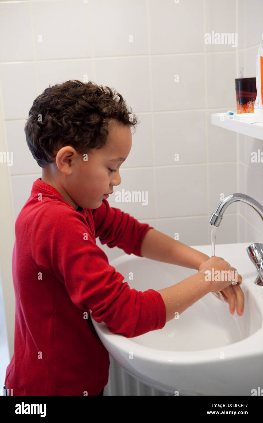 Seven year old boy washing his hands Stock Photo