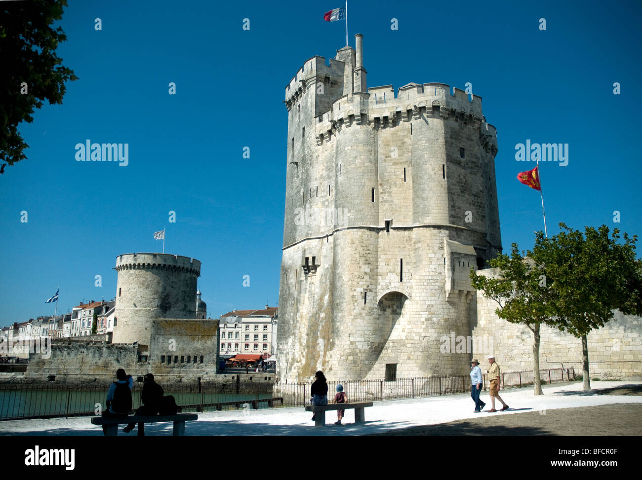 On a sunny afternoon peope enjoy the view of La Rochelle's great Old Port towers, St-Nicolas, right, and La Chaîne Stock Photo