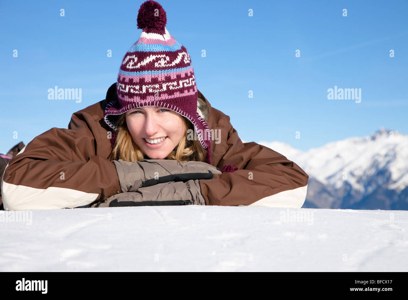 Young woman lying down on snow. Copy space Stock Photo