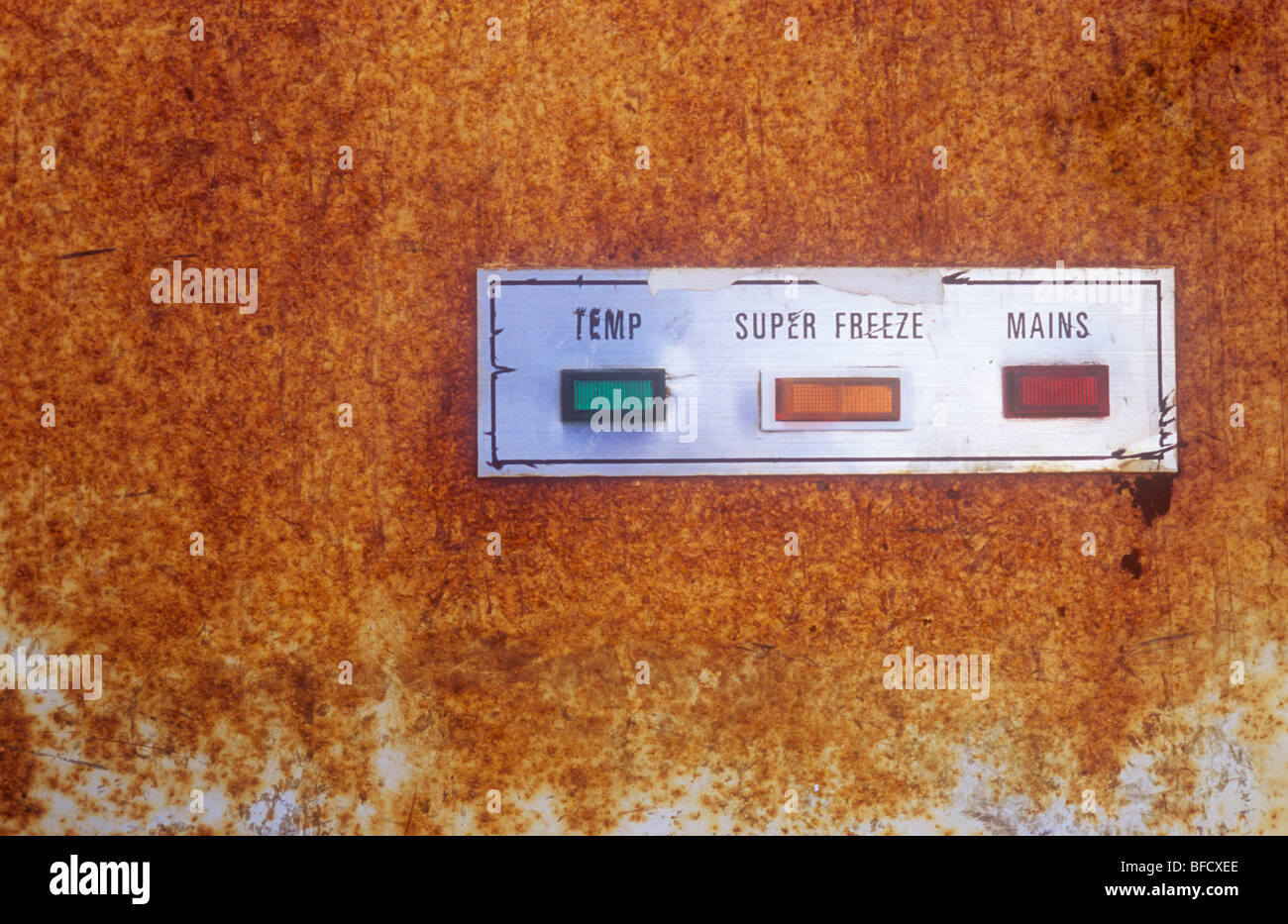 Close up of rusty panel of old freezer cabinet with lights indicating Temp and Mains and switch for Super Freeze Stock Photo