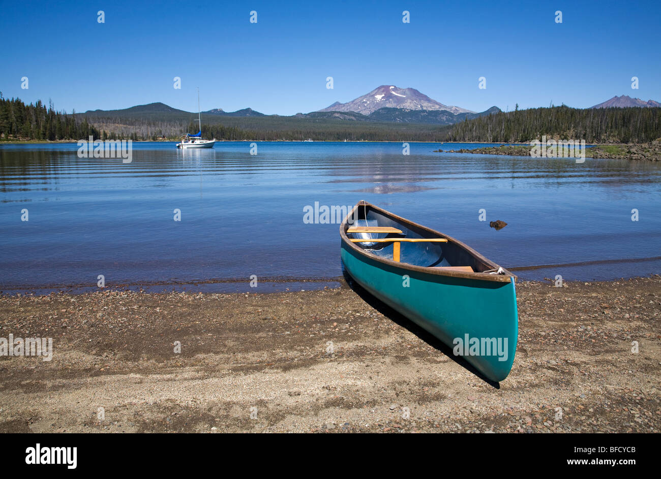 A canoe and a sailboat on Elk Lake in the Oregon Cascade Mountains along the Cascade Lakes Highway Stock Photo