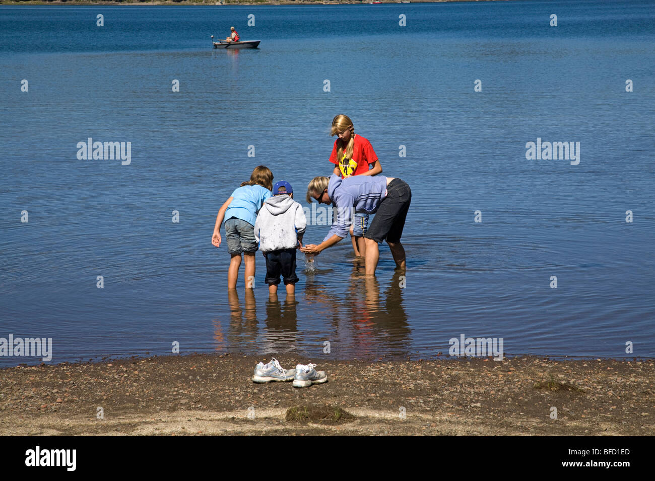 Children on a family outing hunt for crawdads in Elk Lake in the Oregon Cascade Mountains along the Cascade Lakes Highway Stock Photo