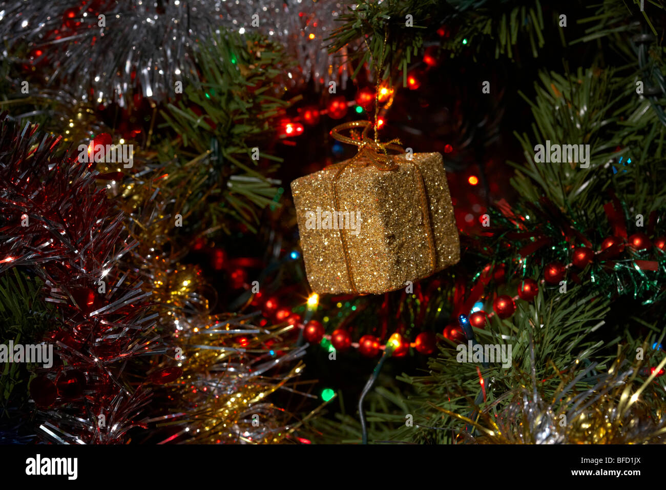 Small Golden Parcel Decoration Hanging On An Artificial Christmas