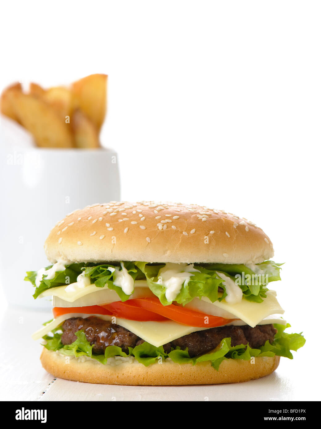 Hamburger with fries in background on white table Stock Photo