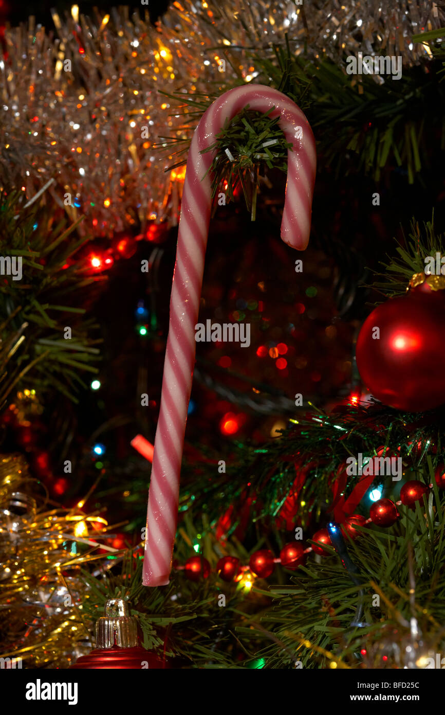 candy cane decoration hanging on an artificial christmas tree Stock Photo
