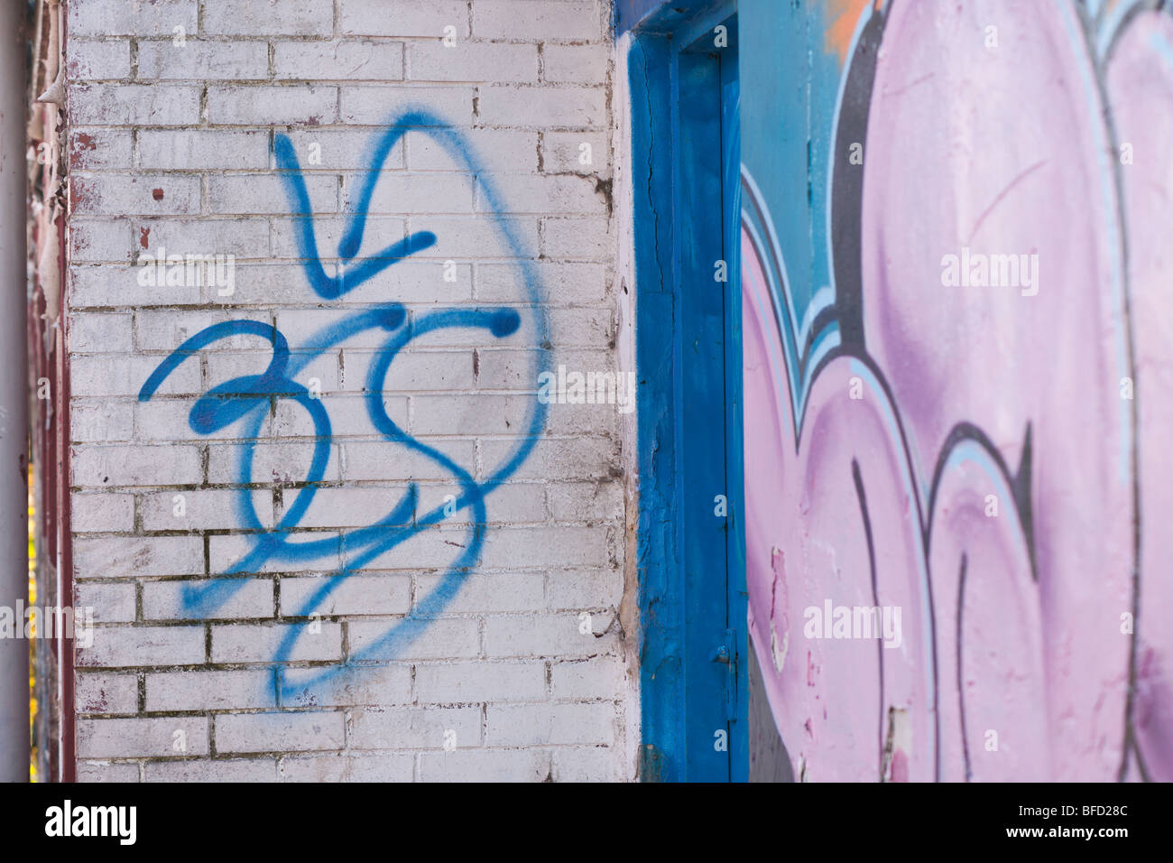 Graffiti tag spray painted on a brick wall. Vandalism by youths, hoodies. Inner city Sneinton Nottingham. Stock Photo