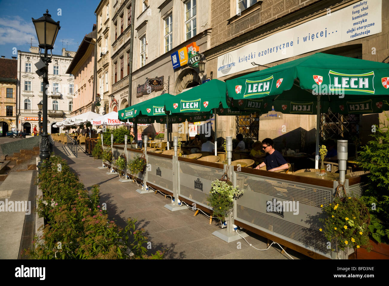 Open air pavement cafe bar tables with umbrellas in the square bounded