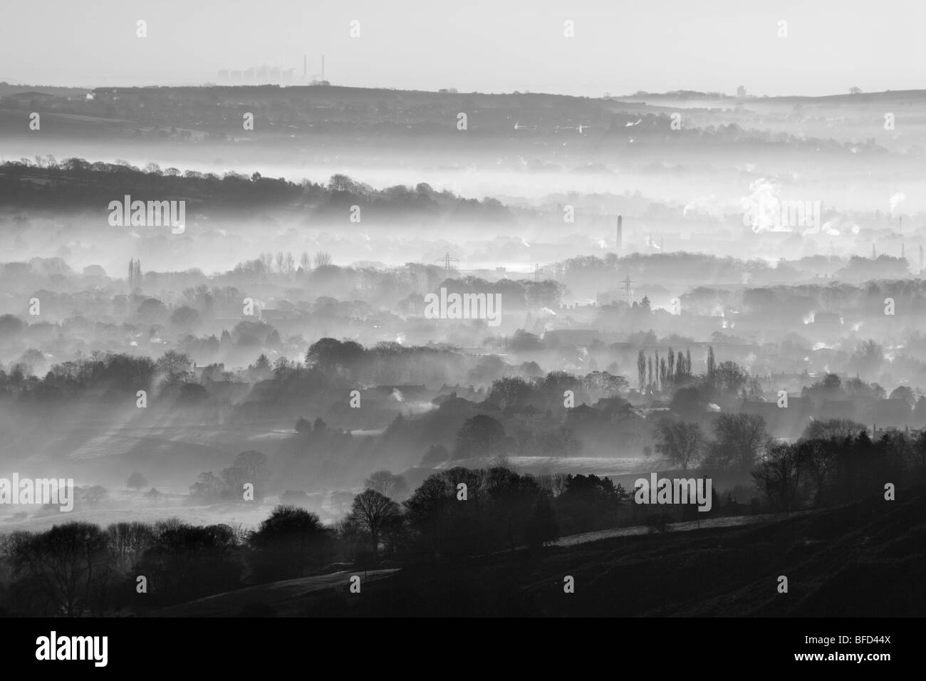 Sunrise, and mist fills the valley of Wharfedale.  A view from Ilkley Moor in West Yorkshire of the town of Menston Stock Photo