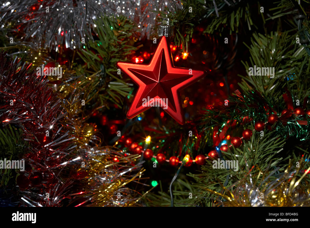 red star decoration hanging on an artificial christmas tree Stock Photo