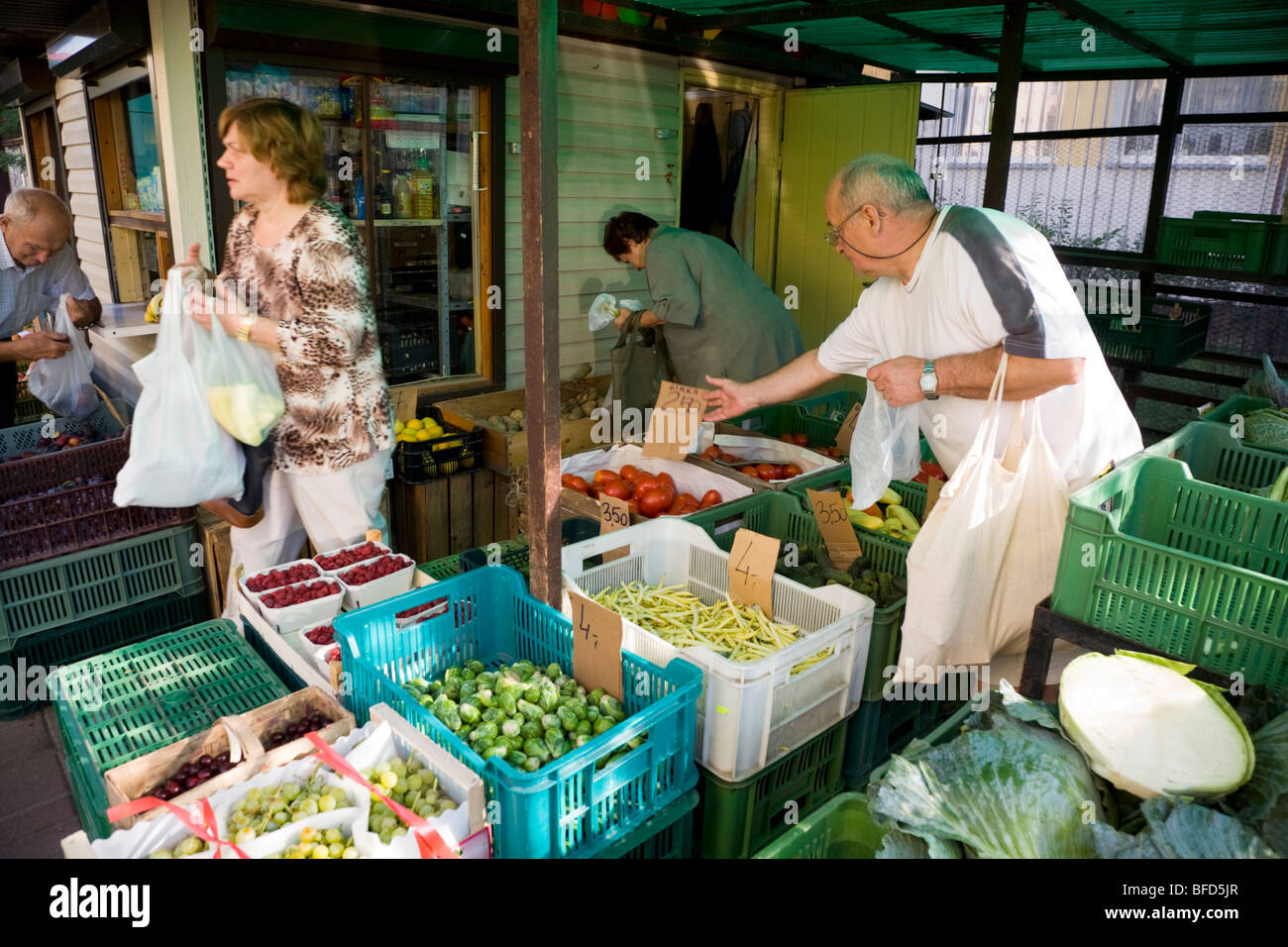 Customers shop at fresh fruit & vegetable local market stall on Polish residential housing estate. Kedzierzyn-Kozle town. Poland Stock Photo