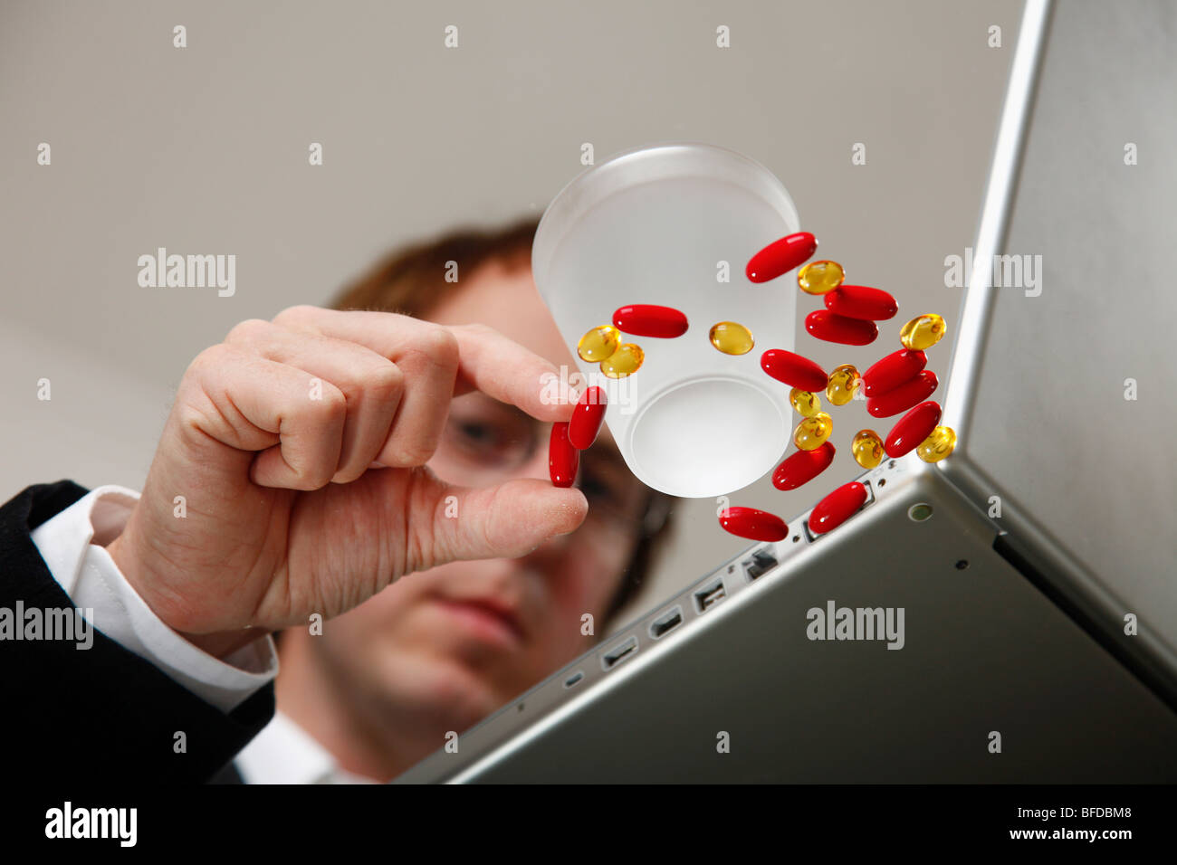 Businessman with pills at his computer Stock Photo