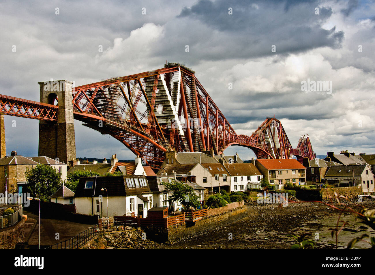 Forth Rail Bridge, Scotland with houses and the mudflats of the Firth of Forth in the foreground. Stock Photo