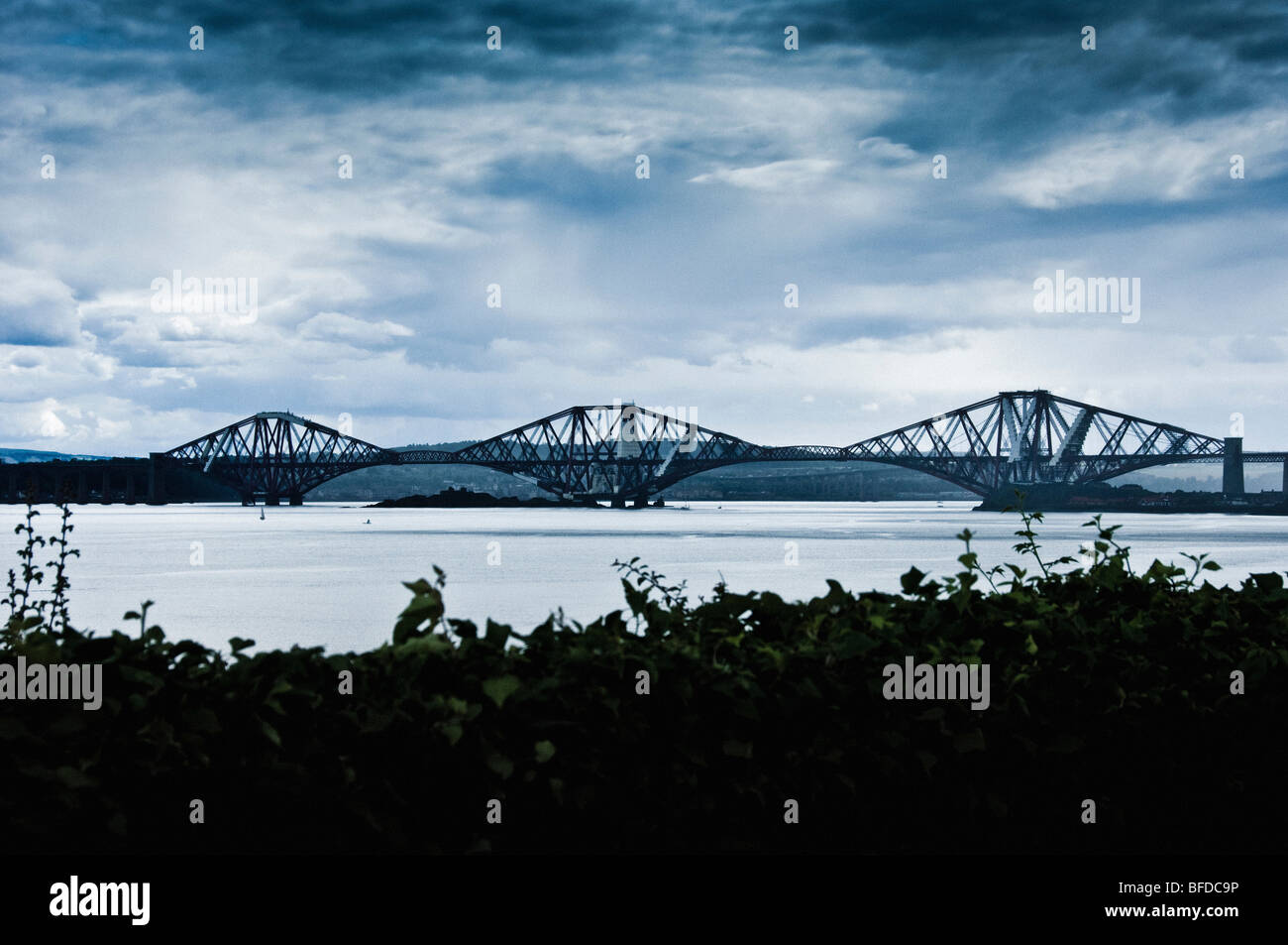 Forth Rail Bridge, silhouetted against a cloudy sky. Stock Photo