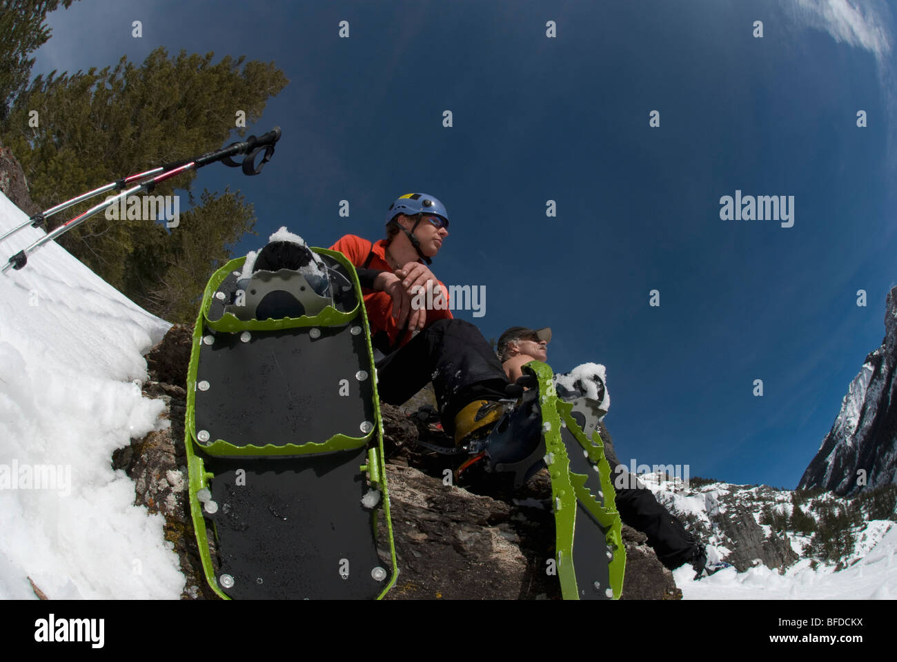 Two men rest under blue skies while snowshoeing near Ouray, Colorado
