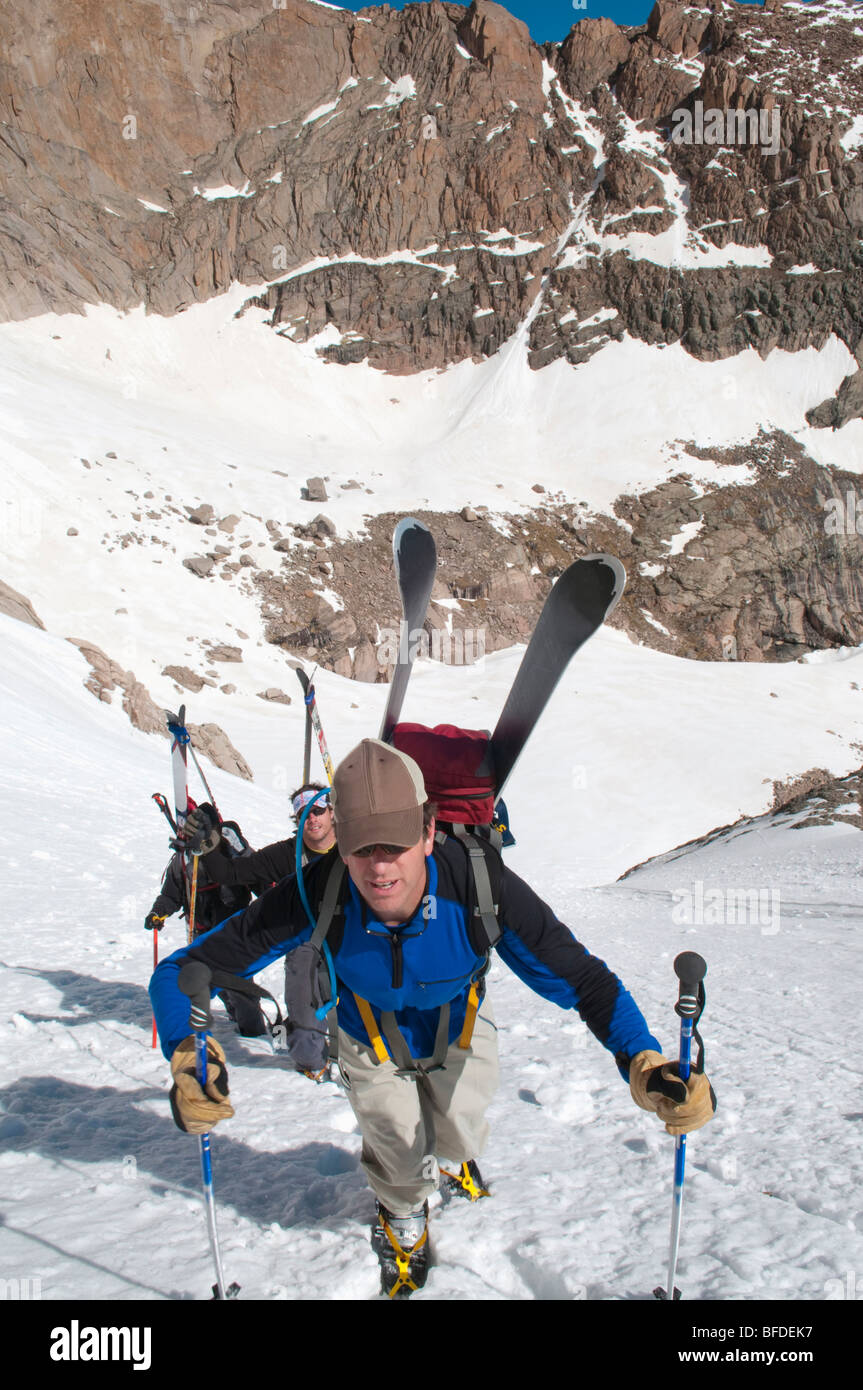 Three backcountry skiers approach a couloir in the spring in Rocky Mountain National Park, Colorado. Stock Photo