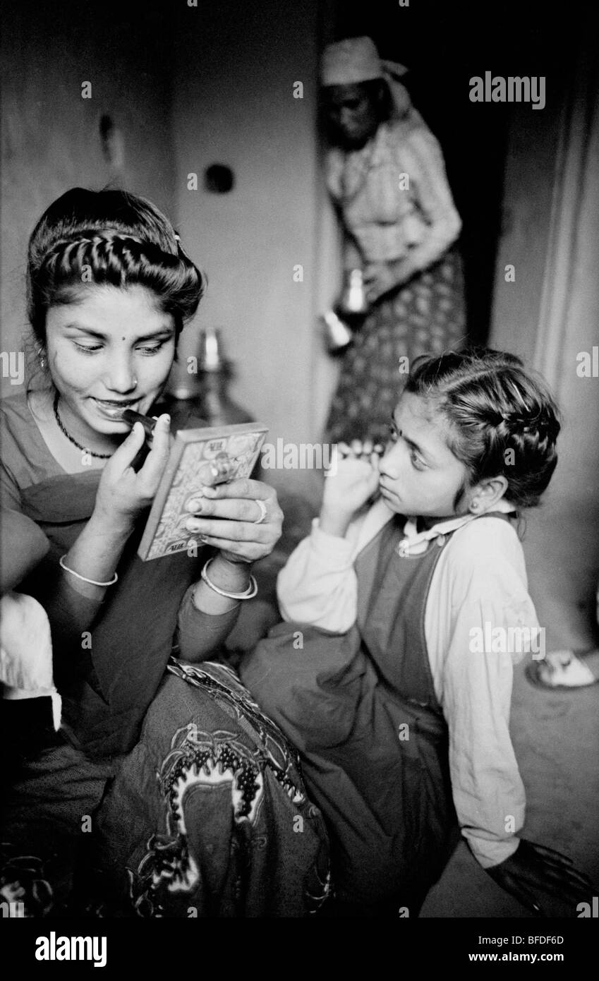 A woman of the Badi sex worker caste prepares herself for clients while her mother and younger sister look on. Stock Photo