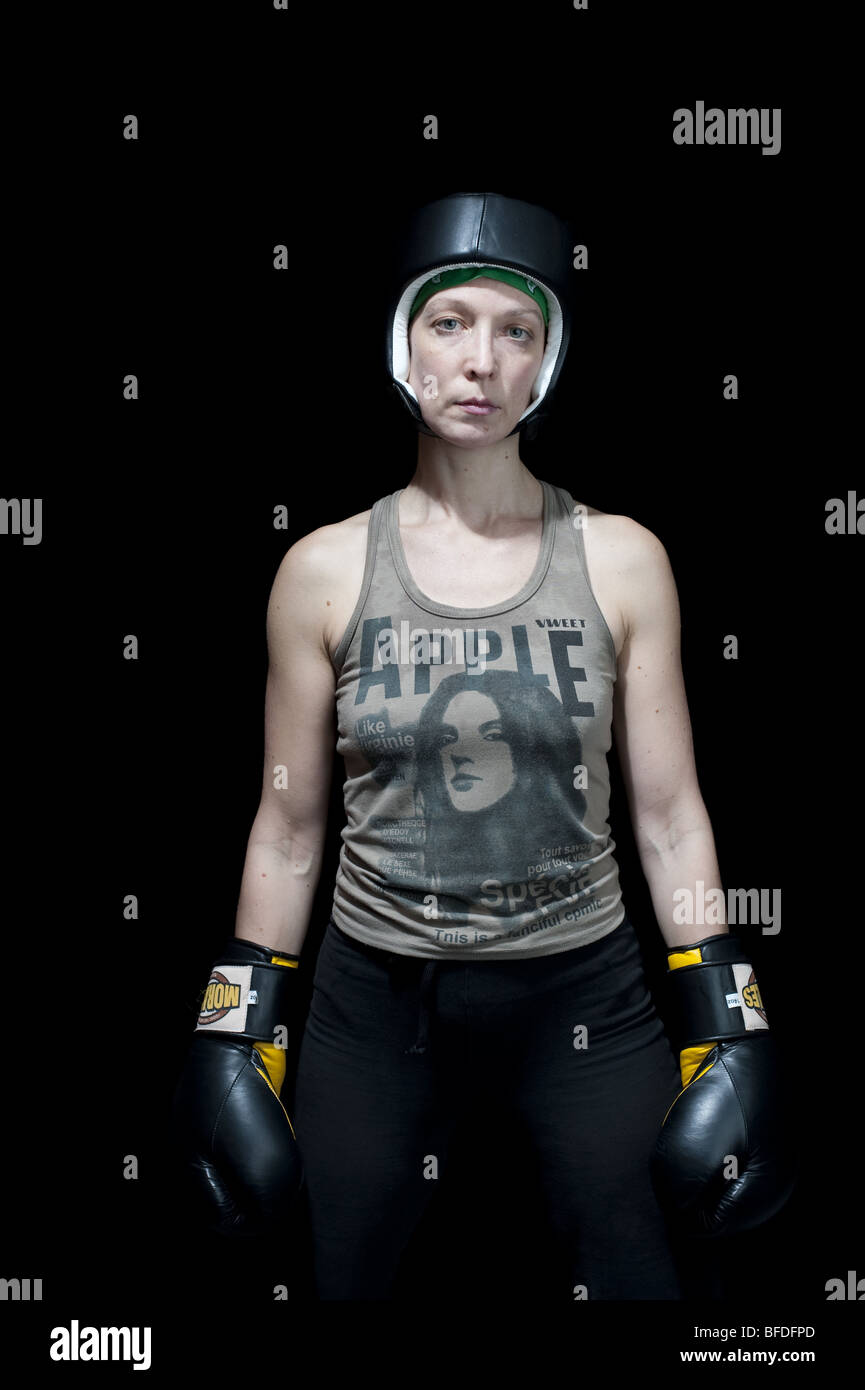 Three quarter portrait of female boxer wearing headgear and boxing