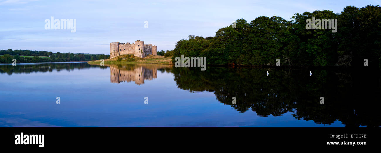 The last of the evening sunlight reflecting off Carew Castle beside the Carew River at Carew, Pembrokeshire, Wales Stock Photo
