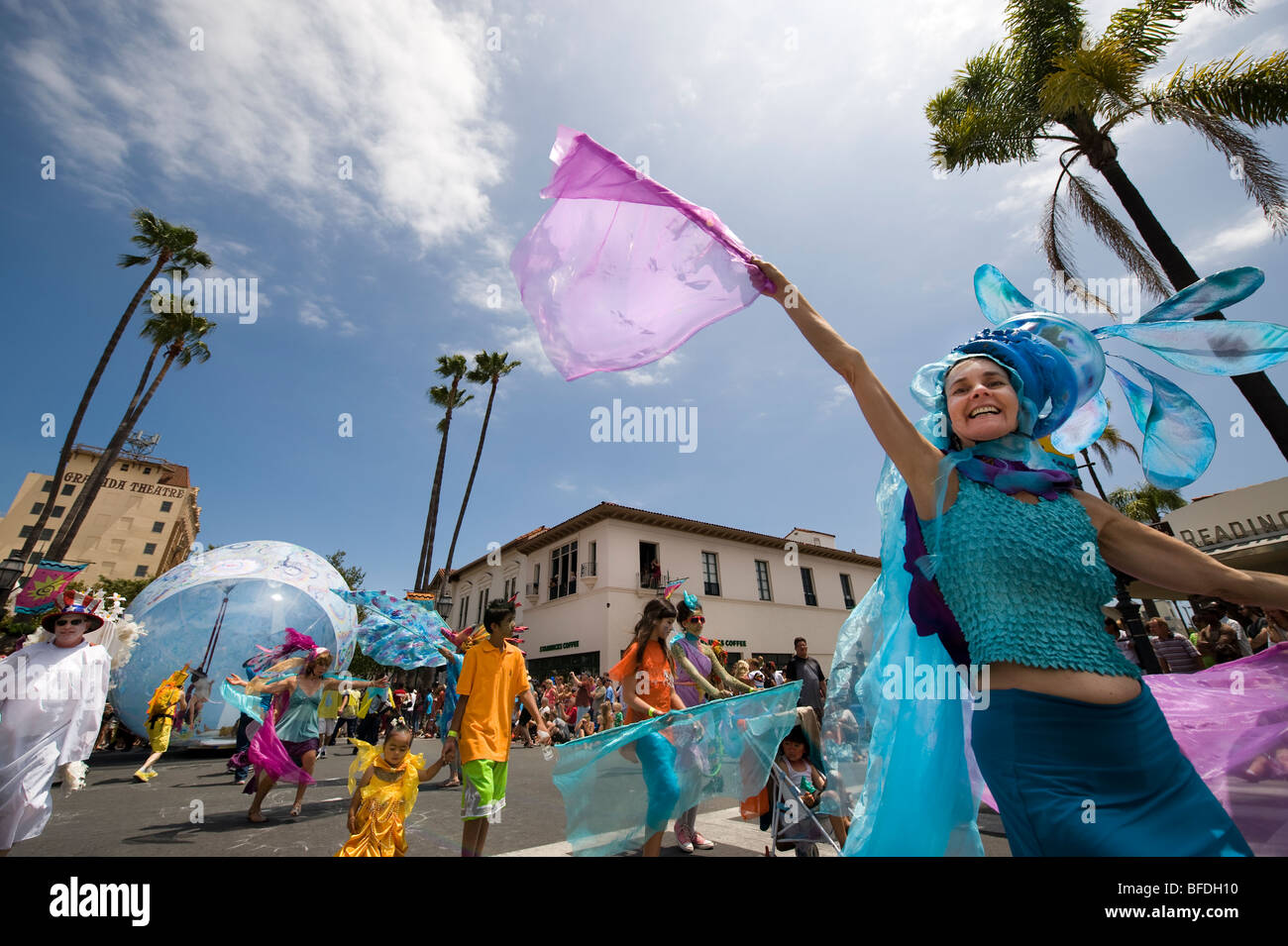 A woman waves her silk flag during a parade in Santa Barbara. The