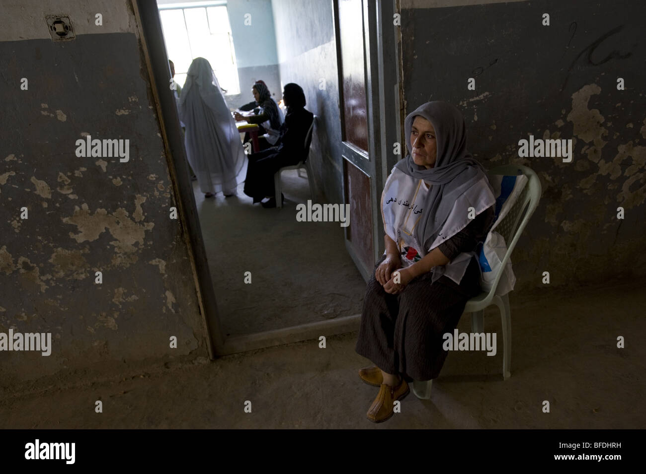 An Afghan poll worker sits by the door of a polling room on the morning of election day,  in Mazar-i Sharif, Afghanistan at Augu Stock Photo