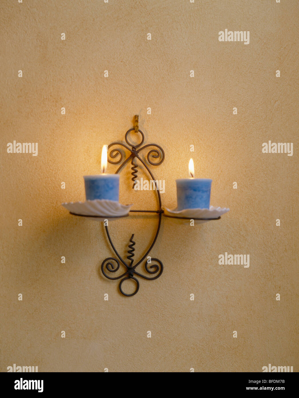 Close-up of blue candles on metal wall-sconce Stock Photo